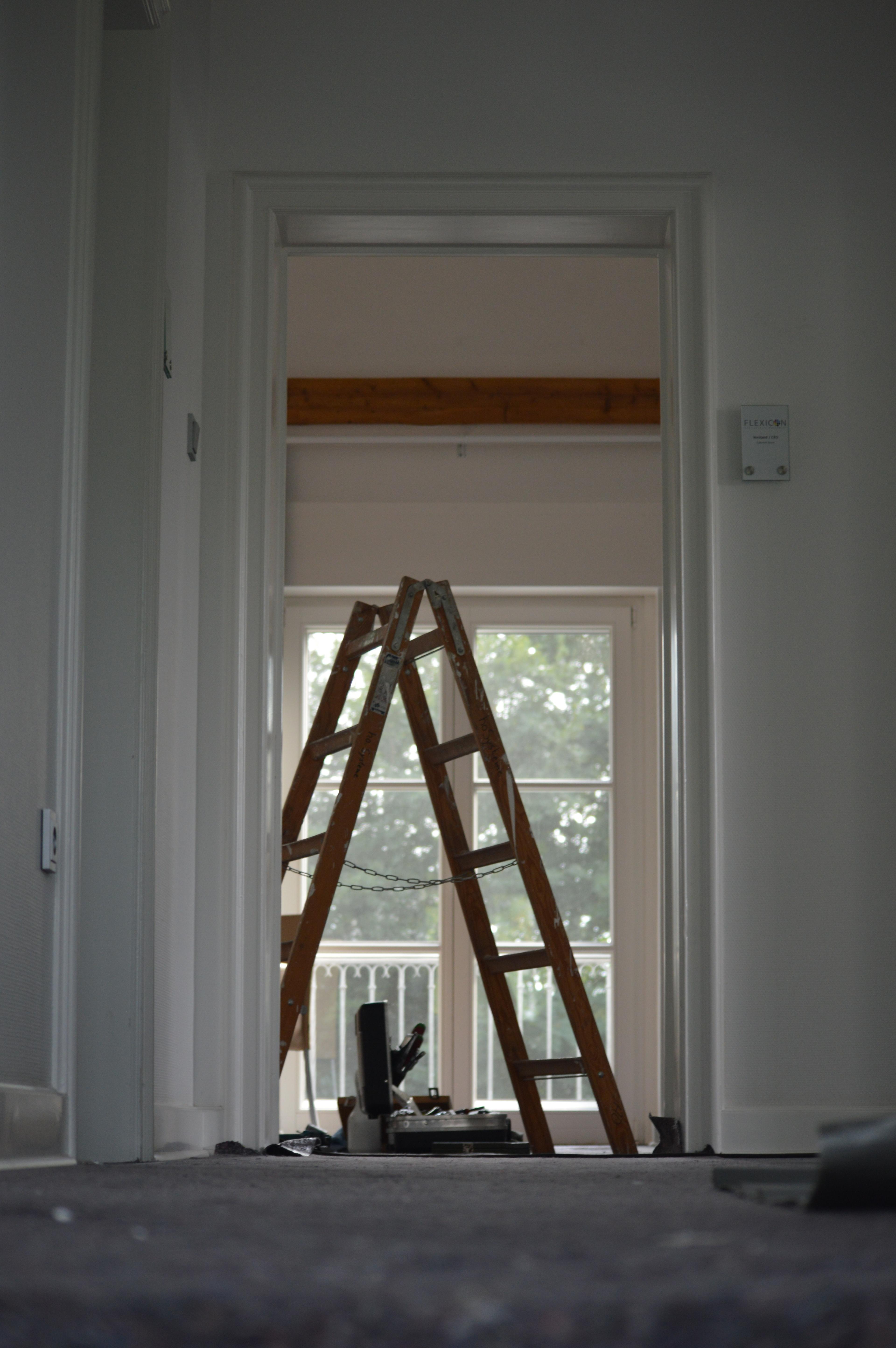 Wooden ladder in doorway of house undergoing renovation